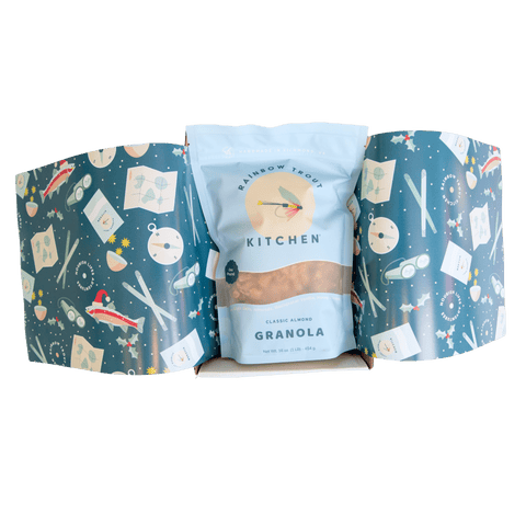 Granola package from Rainbow Trout Kitchen in a decorative box with outdoor adventure-themed holiday design.